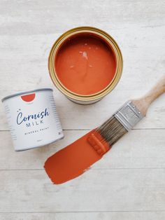 a paint can and brush sitting on top of a white table