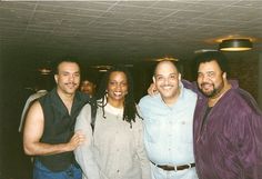 three men and one woman posing for a photo