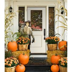 pumpkins and gourds are sitting on the front porch