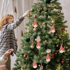 two children decorating a christmas tree with ornaments