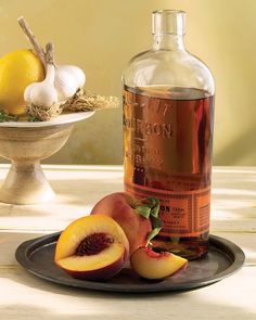 a bottle of peach tea sitting on top of a plate next to sliced peaches