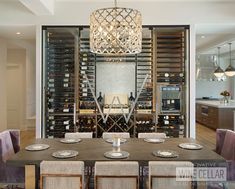 a dining room table with plates and wine bottles on the wall in front of it