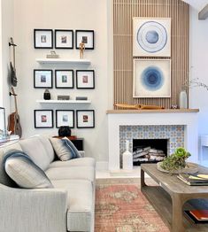 a living room filled with furniture and framed pictures on the wall above a fire place