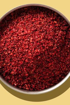 a metal bowl filled with red food on top of a table