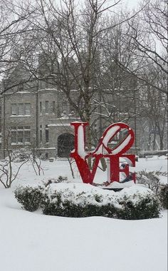 a large love sign in the middle of a snow covered park