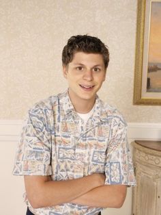 a man with his arms crossed standing in front of a mirror that says, michael cera getting progressively younger since 2003