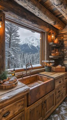 a rustic kitchen with wooden cabinets and an open window overlooking the snowy mountain range in winter