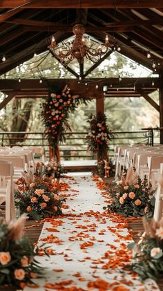 the aisle is decorated with orange flowers and greenery