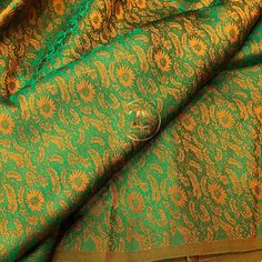 green and gold brocaded fabric with sunflowers on it