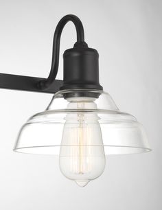 an industrial style light fixture with clear glass shade and black metal arm, on a white background