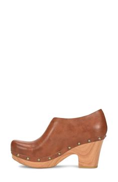 A half d'Orsay upper adds unique style to this 60s inspired clog. 2.5" heel, 1" platform Round toe Stud details Slip-on Wood heel Manmade upper and sole Imported Brown High Heel Clogs With Sculpted Heel, Modern Clogs With Wooden Wedge Heel, Retro Platform Clogs With Round Toe, Retro Style Platform Clogs With Round Toe, Retro Leather Clogs, Retro Mules With Stacked Heel And Round Toe, Wood Heel, Women's Pumps, Nordstrom Rack