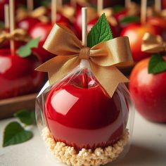 an apple with a bow on it is sitting in front of other apples and lollipops