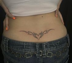 a woman's stomach with a tattoo on her lower back and the bottom part of her belly