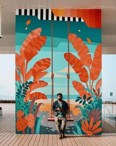 a man sitting on a bench in front of a painting that looks like tropical plants