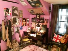 a bedroom with pink walls and lots of pictures on the wall, including an old fashioned guitar