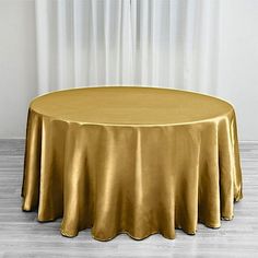 a round gold tablecloth on a wooden floor