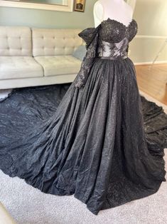 a dress on display in a room with a white couch and mirror behind it,