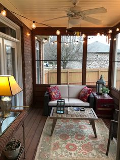 a living room with a couch, coffee table and ceiling fan