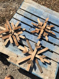 a snowflake made out of wood sitting on top of a wooden pallet