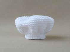 a crocheted white hat sitting on top of a table