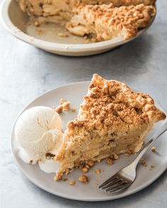 a piece of pie on a plate with ice cream and a fork next to it