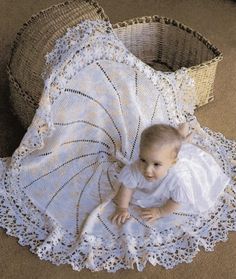 a baby is laying on the floor next to an empty basket and lace doily