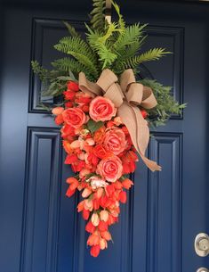 a wreath with flowers hanging on the front door