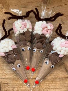 some kind of candy with eyes and noses on them in plastic bags sitting on top of a wooden table