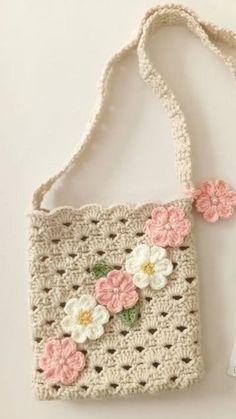 a crocheted purse with flowers on it and a tag attached to the handle