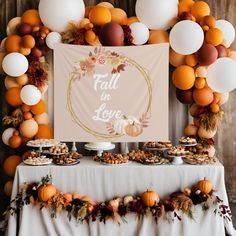 a table topped with lots of desserts and balloons in front of a sign that says fall is love