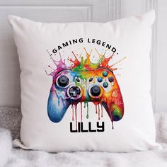 a white pillow with a colorful video game controller on it that says gaming legend lilly