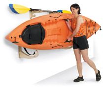 a woman standing next to an orange kayak