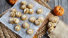 some cookies are sitting on a table with pumpkins