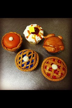 four decorated cupcakes sitting on top of a table