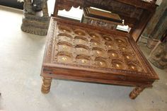 a wooden table with carvings on it in a room