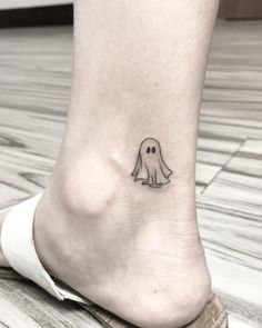 a small ghost tattoo on the ankle