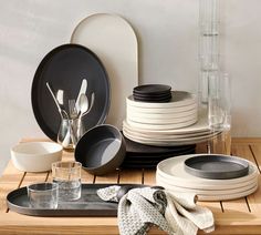 a table topped with plates and glasses on top of a wooden table covered in dishes