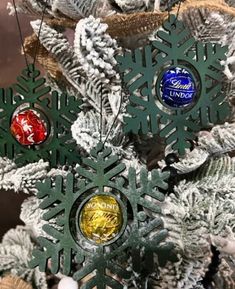 a christmas tree with ornaments hanging from it's branches and snowflakes on top