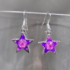 One of a kind hand painted (gradient purple blend) and resin (creates a glass like finish) dangling star earrings.  Embellished with embedded Austrian crystal (electric violet) star charms are silver plated pewter. Hung on sterling silver .925 stamped French ear wires.  Approximate length 1.25". Stars are for dreamers, doers and believers. The magic of possibilities is among the stars, in the heavens of our ideas and the wishes we keep or share with the world. Photos taken in studio light.  Free U.S. shipping on orders over $35. International shipping available. Same item as shown, contact me for free sizing adjustments. Shipped in a sealed and protected plastic bag. Free customer consultation offered to create a client profile I keep on hand with measurements and preferences for future or Star-shaped Resin Jewelry For Gifts, Star Shaped Resin Jewelry Gift, Nickel-free Silver Resin Earrings, Silver Resin Earrings As A Gift, Silver Resin Earrings For Gift, Silver Jewelry With Glossy Finish For Gift, Handmade Purple Resin Jewelry, Purple Resin Drop Earrings, Purple Resin Jewelry For Party