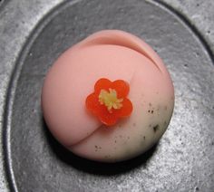 an orange flower sitting on top of a white object in the middle of a metal pan