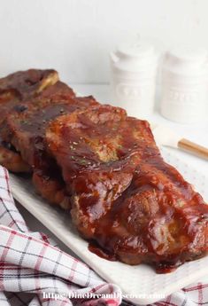 ribs covered in bbq sauce on a white plate