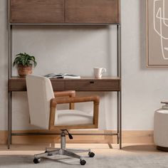 a desk with a chair, potted plant and books on it in front of a white wall