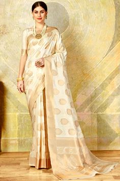 Elevate your ethnic wardrobe with this stunning handloom silk saree in a vibrant Cream Color and gold Zari combination, perfect for festive occasions, weddings, and special events. Expertly crafted by skilled artisans, this saree showcases intricate Banarasi weaving patterns that radiate elegance and timeless charm. The saree features a luxurious gold Zari border and traditional motifs, lending it an opulent finish. The soft silk fabric drapes gracefully, providing both comfort and style. This saree comes with an unstitched matching blouse piece, allowing you to customize your look to perfection. Whether you're attending a cultural celebration or a wedding, this traditional handloom saree is sure to make a lasting impression. Pair it with your favorite jewelry and accessories to complete y Cream Color Saree, Handloom Silk Saree, Festival Mode, Brocade Saree, Weaving Designs, Art Silk Sarees, Festive Wear, Indian Ethnic Wear, Draped Fabric