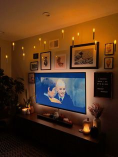 a flat screen tv sitting on top of a wooden table in a living room next to a potted plant