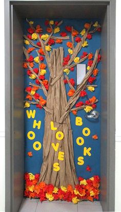 a door decorated with fall leaves and a book cover that says who loves books?