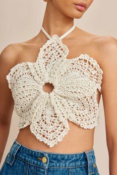 a woman wearing a white crochet top with a flower on the front and back