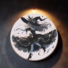 a white plate with an image of a woman on it hanging from a wall light