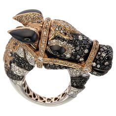 In the world of jewelry, there are pieces that transcend craftsmanship and become timeless works of art. The Arabian Elegance Ring is one such masterpiece, a dazzling tribute to the grace and majesty of the Arabian horse, crafted with the rarest of gemstones. This exceptional ring is a symphony of elegance, combining the striking contrast of black, white, and yellow diamonds to create a mesmerizing visual spectacle. Each detail of this masterpiece has been meticulously designed to capture the sp Luxury Diamond Ring With Polished Finish, Luxury Evening Rings With Gemstone, Designer Gemstone Ring, Designer Gemstone Ring Jewelry, Designer Jewelry With Brilliant Cut For Formal Occasions, Designer Brilliant Cut Formal Jewelry, Exquisite Black Formal Jewelry, Luxury Evening Ring Jewelry, Luxury Black Hallmarked Jewelry