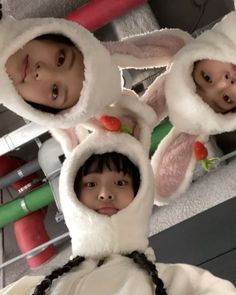 two children wearing bunny ears and holding carrots in front of their faces while standing next to each other