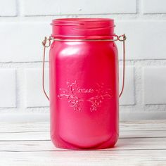 a pink mason jar sitting on top of a wooden table